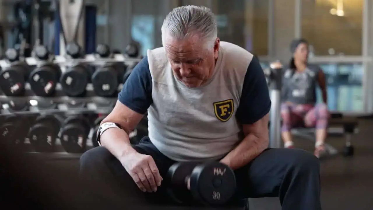 older gentleman lifting weights in a gym