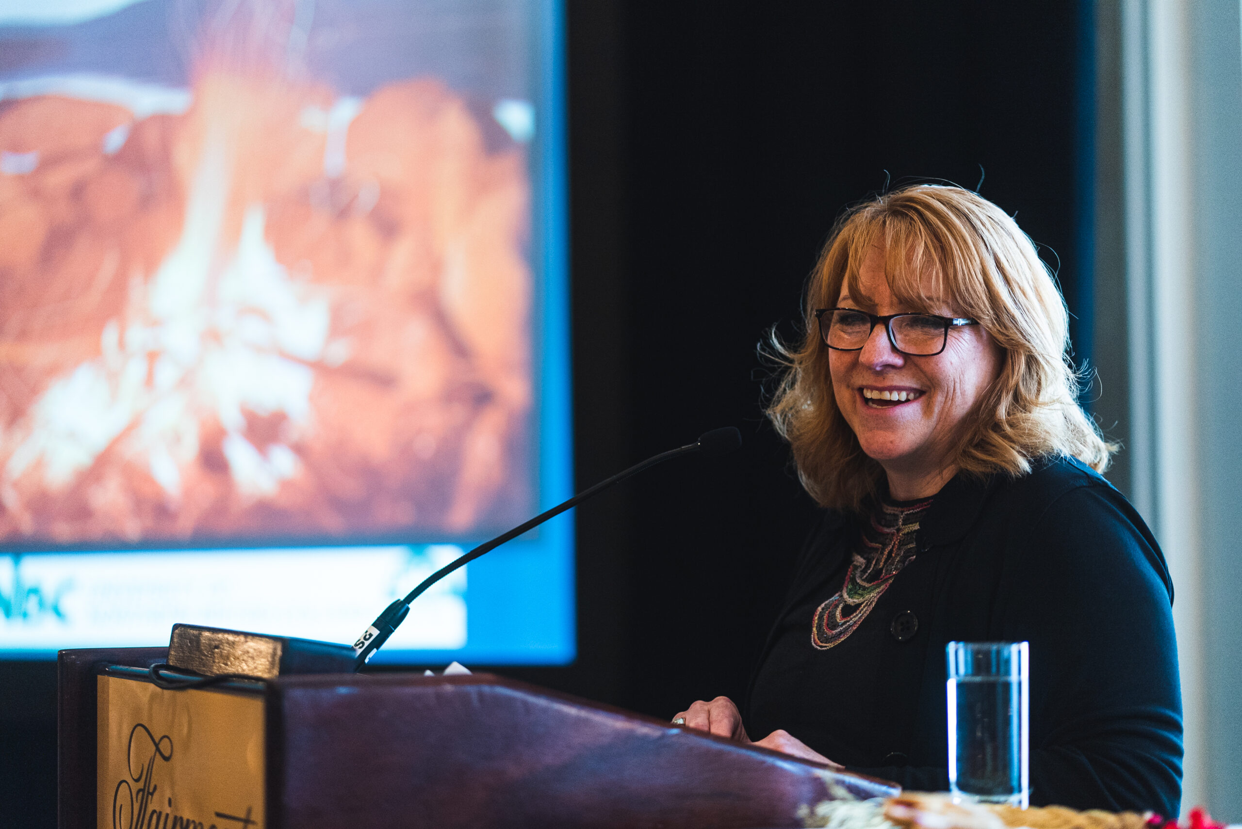 woman giving speech at microphone